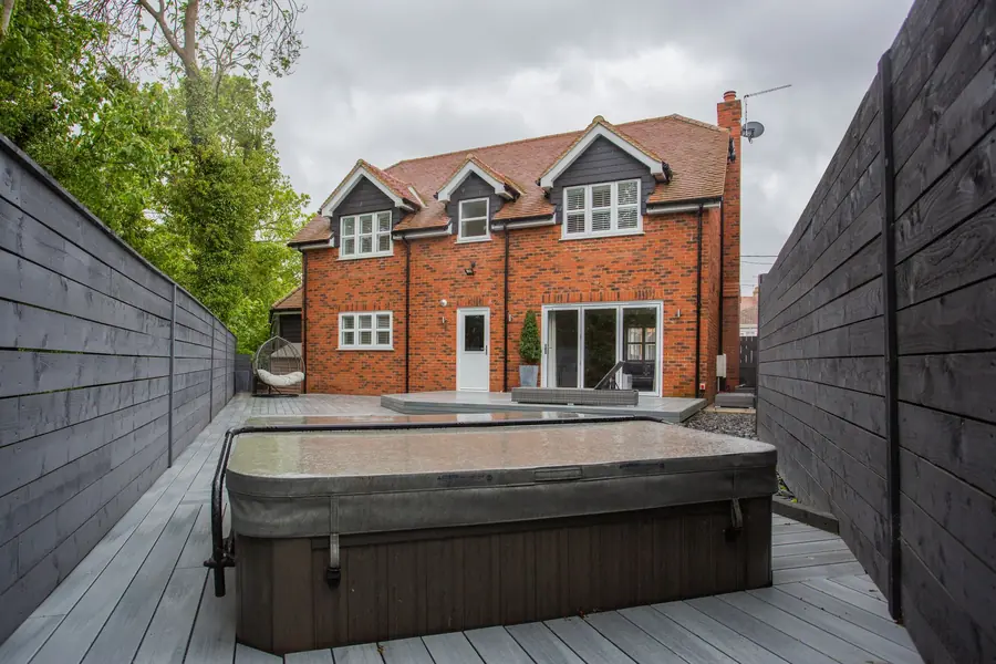 Composite decked terrace and close-board fencing behind a brick house, showing typical hard landscaping costs per square metre in St Albans