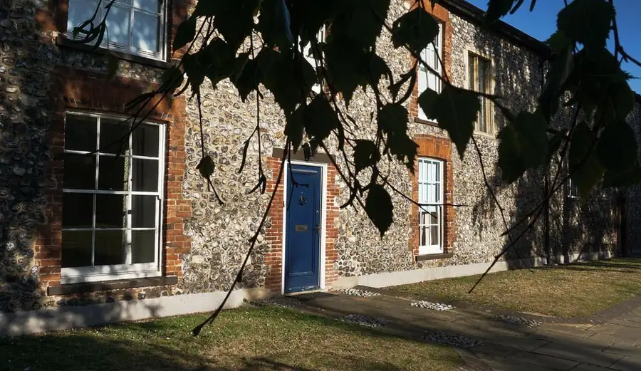 Flint and red brick period house wall with sash windows, the local building material behind St Albans garden design
