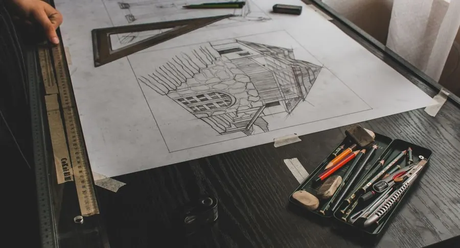 Architectural sketch and drafting tools laid out for a garden design meeting