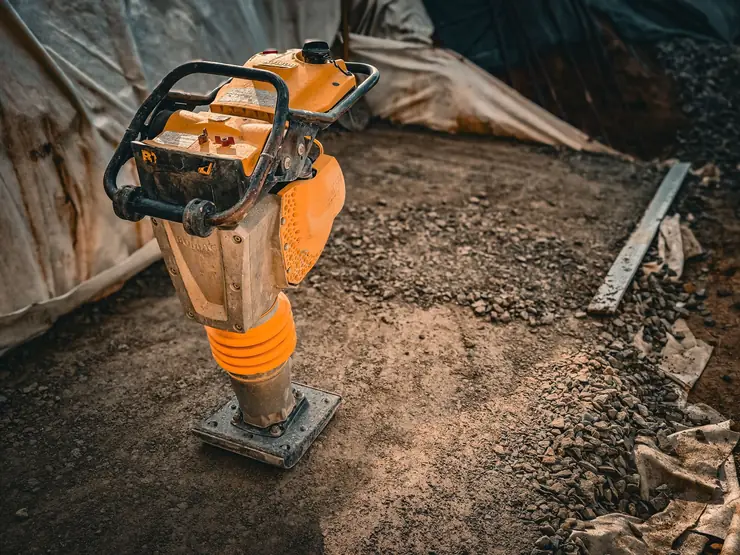 Compaction plate on a hardcore sub-base during phase one groundworks for a St Albans garden
