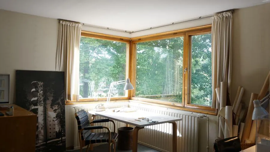 Desk set in a corner window looking out over trees, the kind of garden office that needs power and broadband run to it