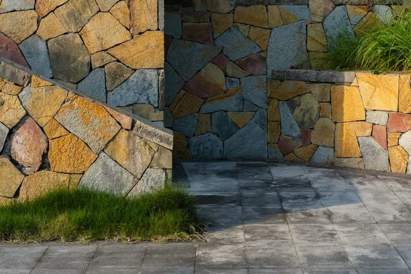 Stone-faced retaining wall meeting a paved terrace, the kind of junction a construction drawing has to specify