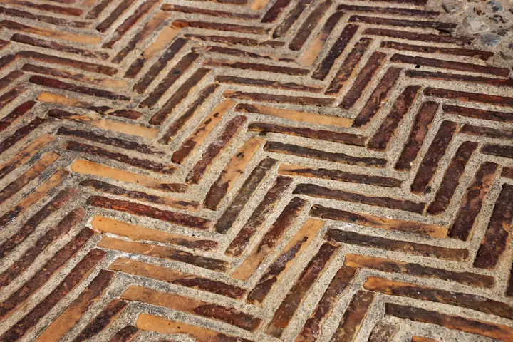 Close view of old clay bricks laid in herringbone, the kind of brick paving that suits Victorian and Edwardian St Albans houses