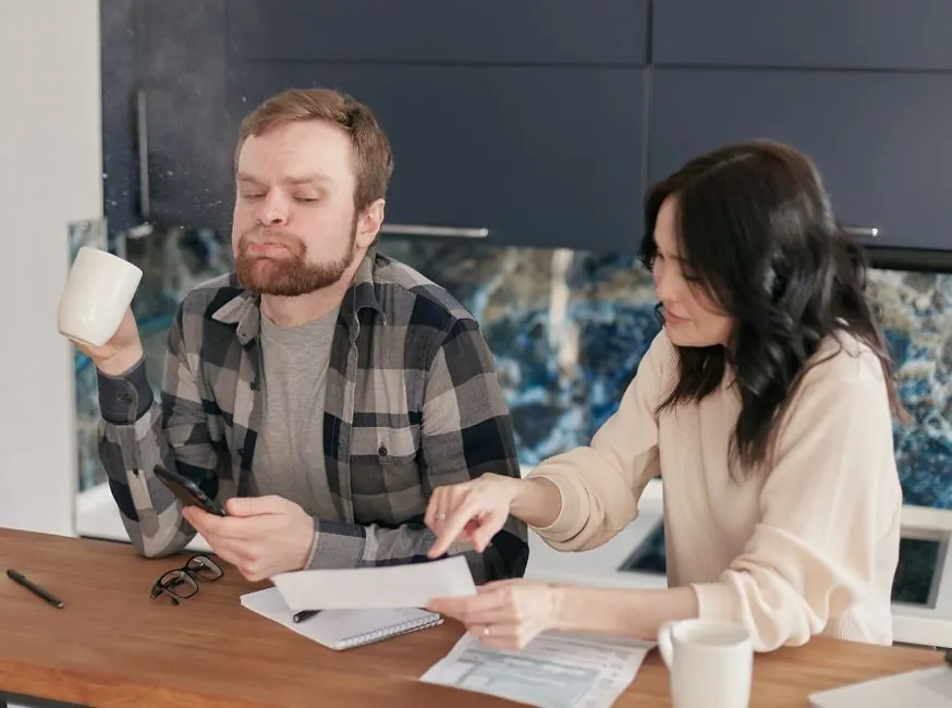 Couple comparing garden quotes and paperwork at their kitchen table