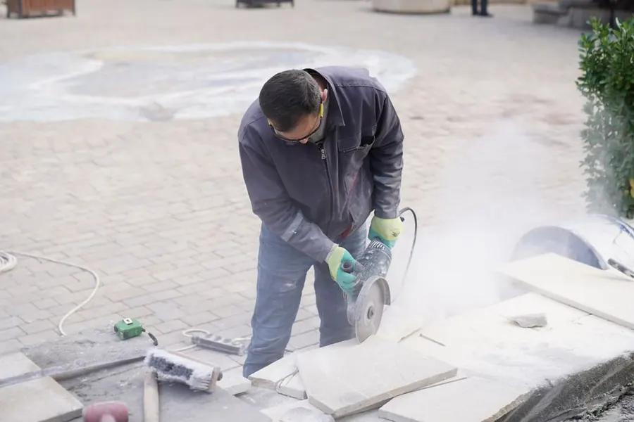 Landscaper cutting stone paving during a garden terrace build