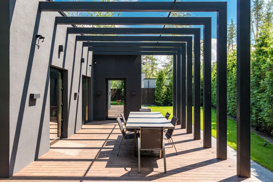 Modern pergola over an outdoor dining table on a timber deck