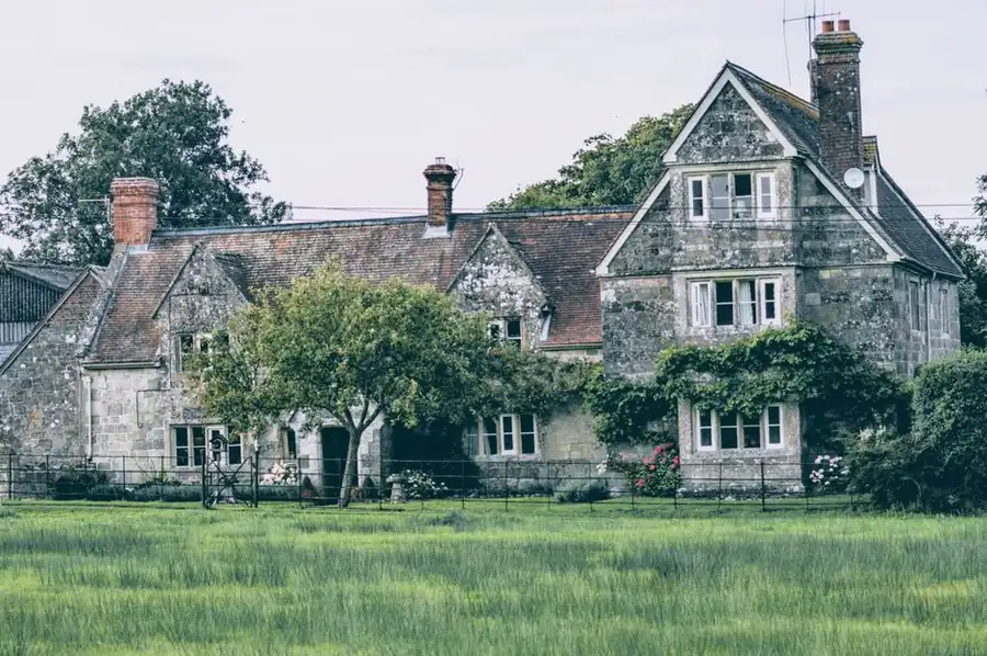 Period stone house with lawn and mature planting, typical of Hertfordshire garden projects