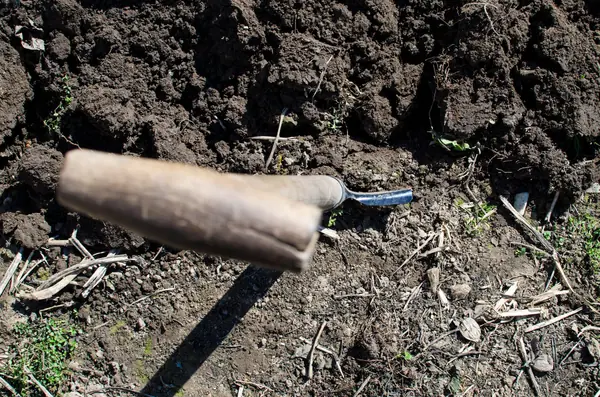 Spade resting in freshly dug soil at the edge of a trial hole, the first step in a soakaway percolation test