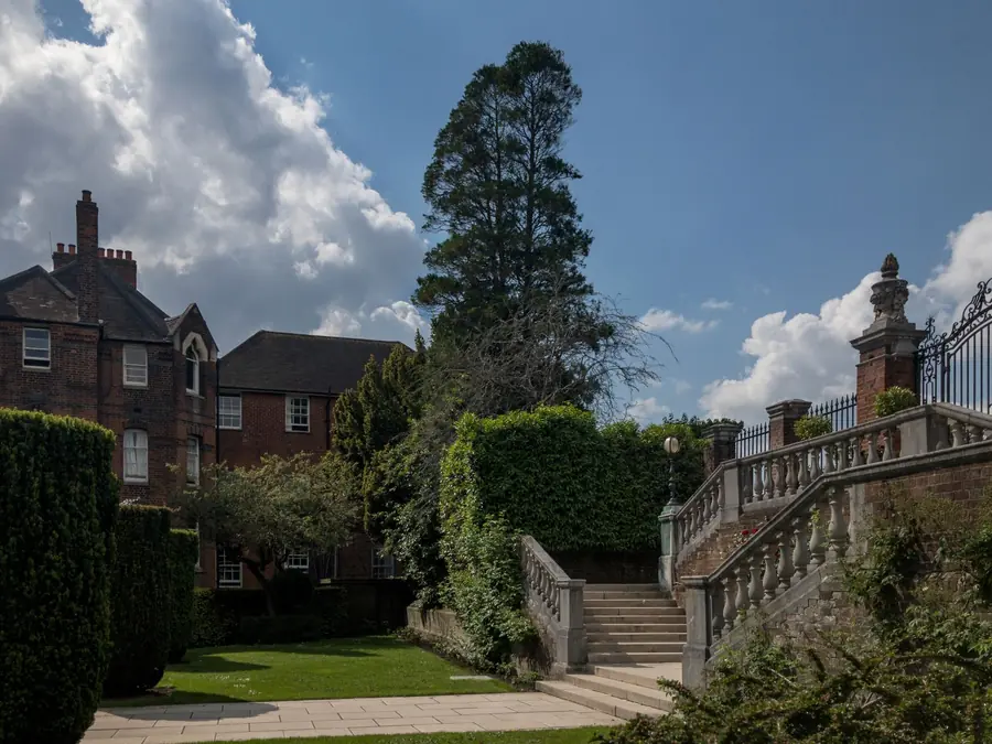 Balustraded stone steps between garden levels behind a Victorian brick house, the kind of level change that needs a topographical survey