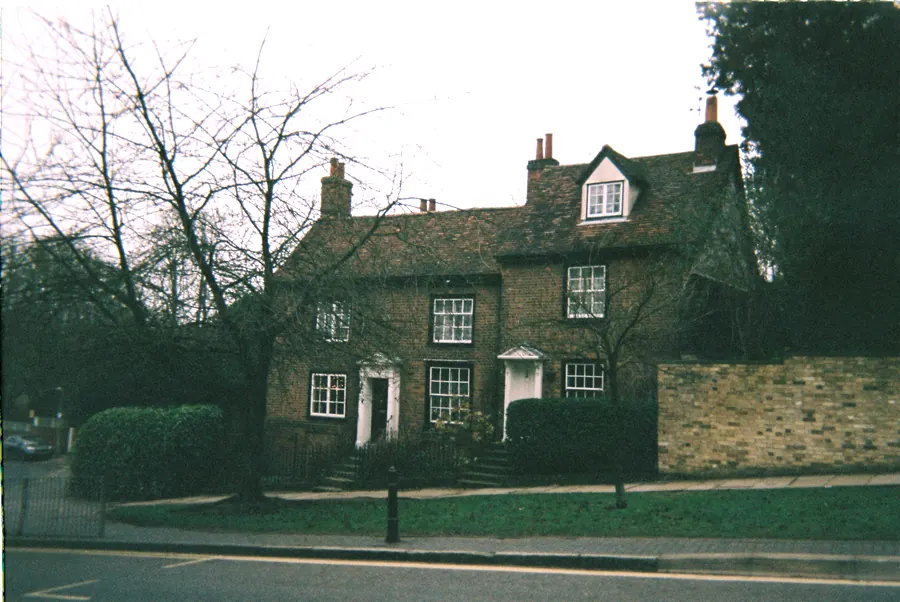 Period brick house with sash windows set behind a brick boundary wall, clipped hedge and railings on a St Albans street, the kind of conservation area frontage planning rules pay attention to