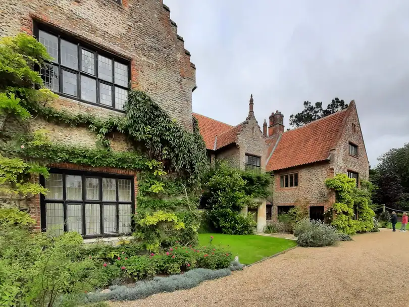 Ivy-covered manor house with gravel forecourt and established planting, the style of garden St Albans designers are often asked for