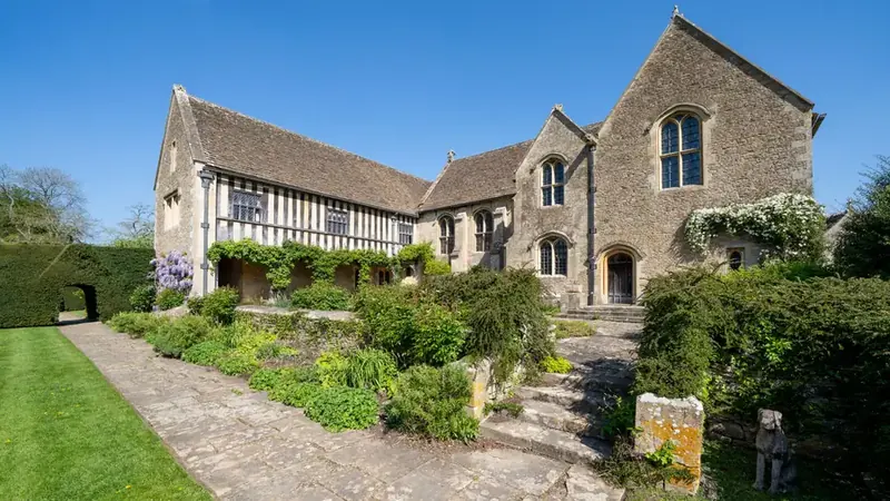 Stone manor garden landscaped into terraces with steps, clipped hedges and layered planting